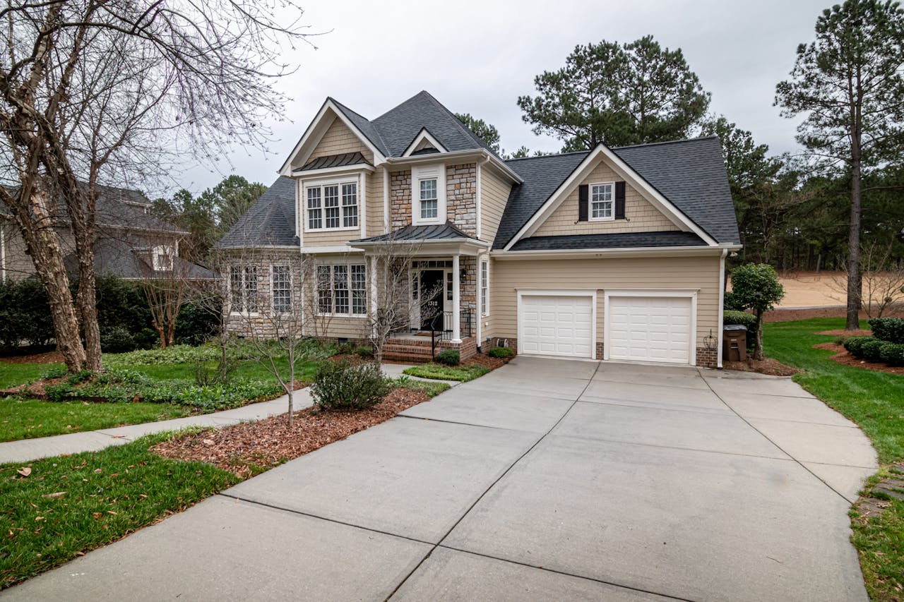 why-choose-us Charming suburban home featuring a two-car garage, manicured lawn, and inviting entrance.
