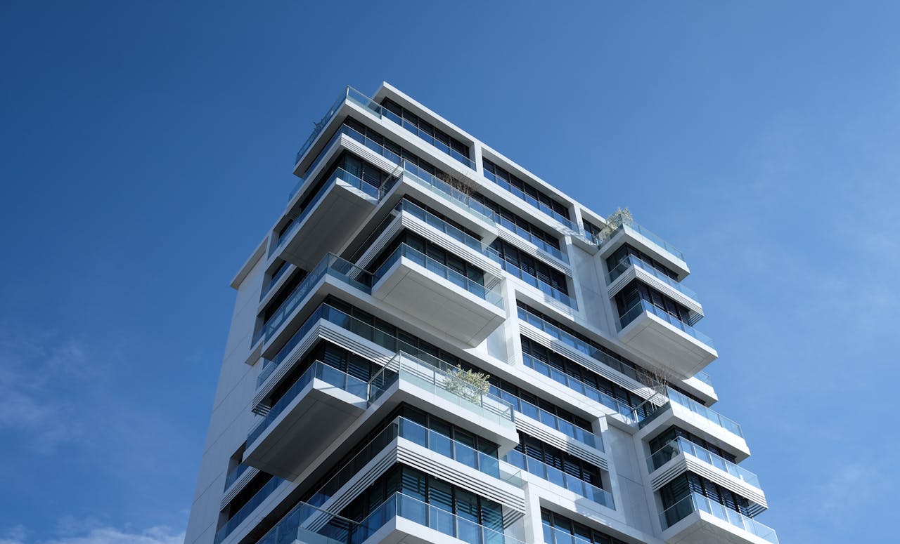 services-04 Striking low-angle shot of a modern condominium with unique balcony design and clear blue sky.